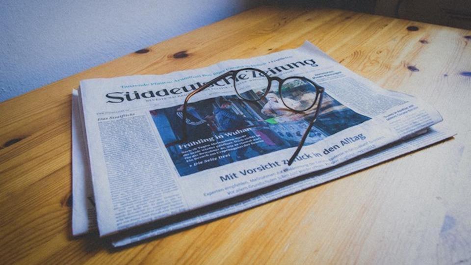 Zeitung mit Lesebrille